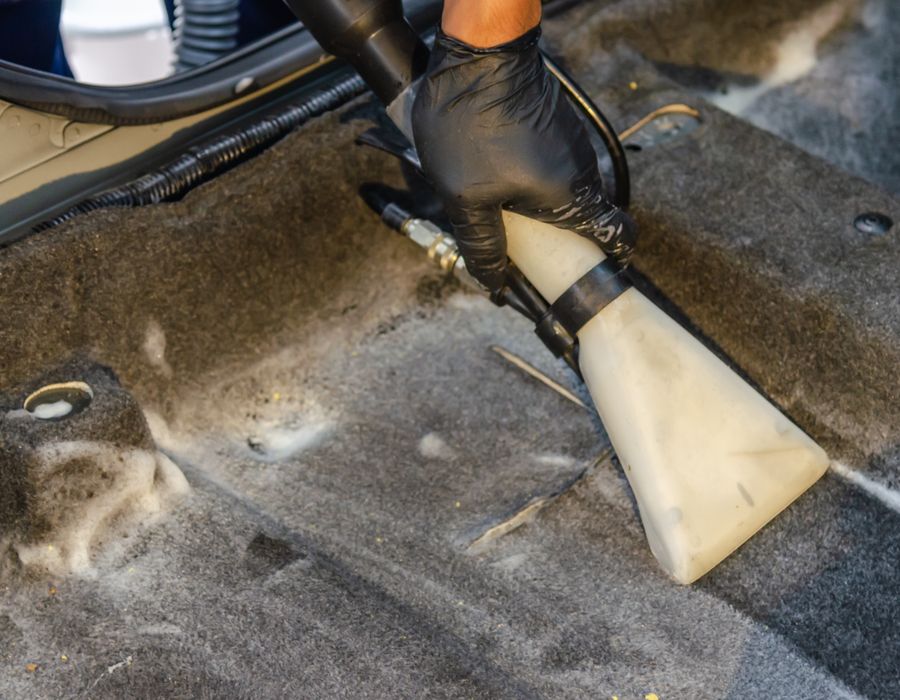 Detalhe da lataria de um carro escuro com reflexo nítido e brilho profundo
