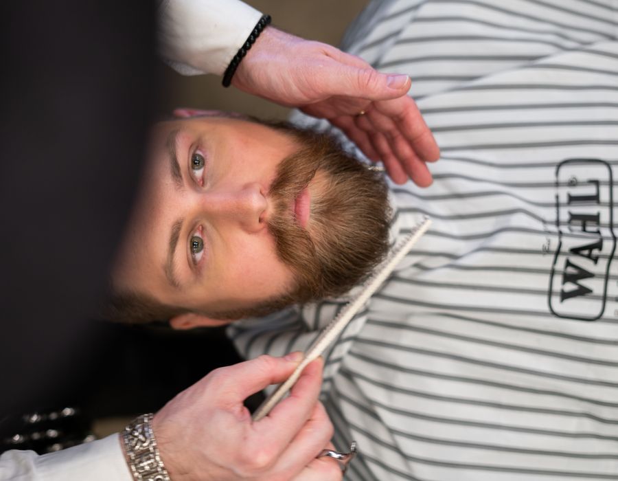 Cliente com corte degradê e barba alinhada finalizado na Navalha & Co.