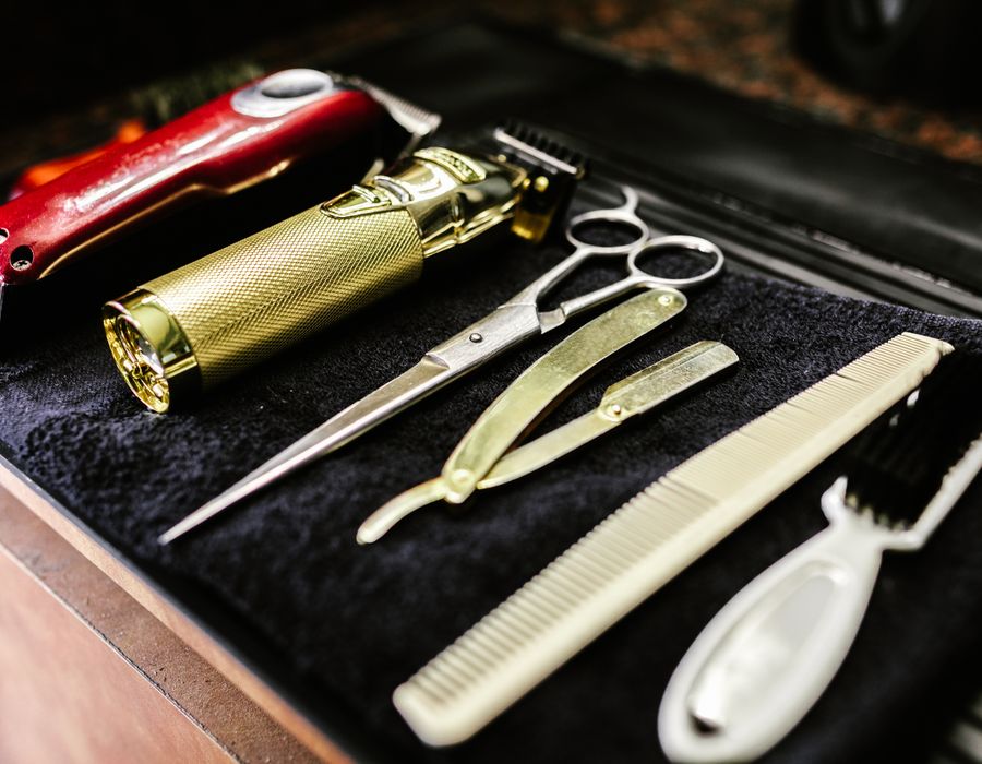 Ambiente vintage-industrial da barbearia com cadeiras de couro e luminárias âmbar