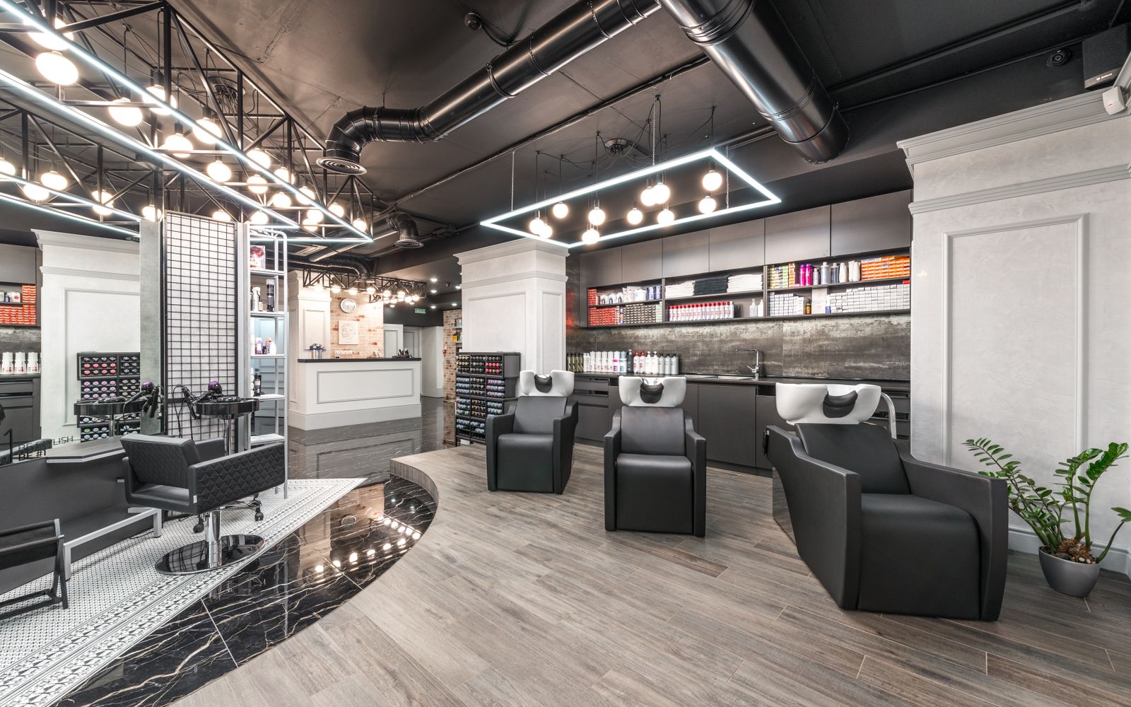Interior da barbearia Navalha & Co. com cadeiras de couro, espelhos e iluminação âmbar