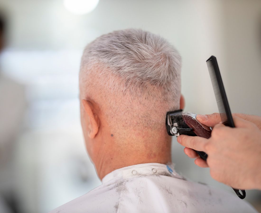 Barbeiro da Navalha & Co. aparando a barba de um cliente com navalha