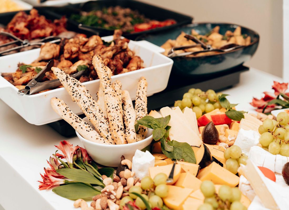Mesa de buffet elegante da Villa Jardim com variedade de pratos, doces finos e arranjos florais