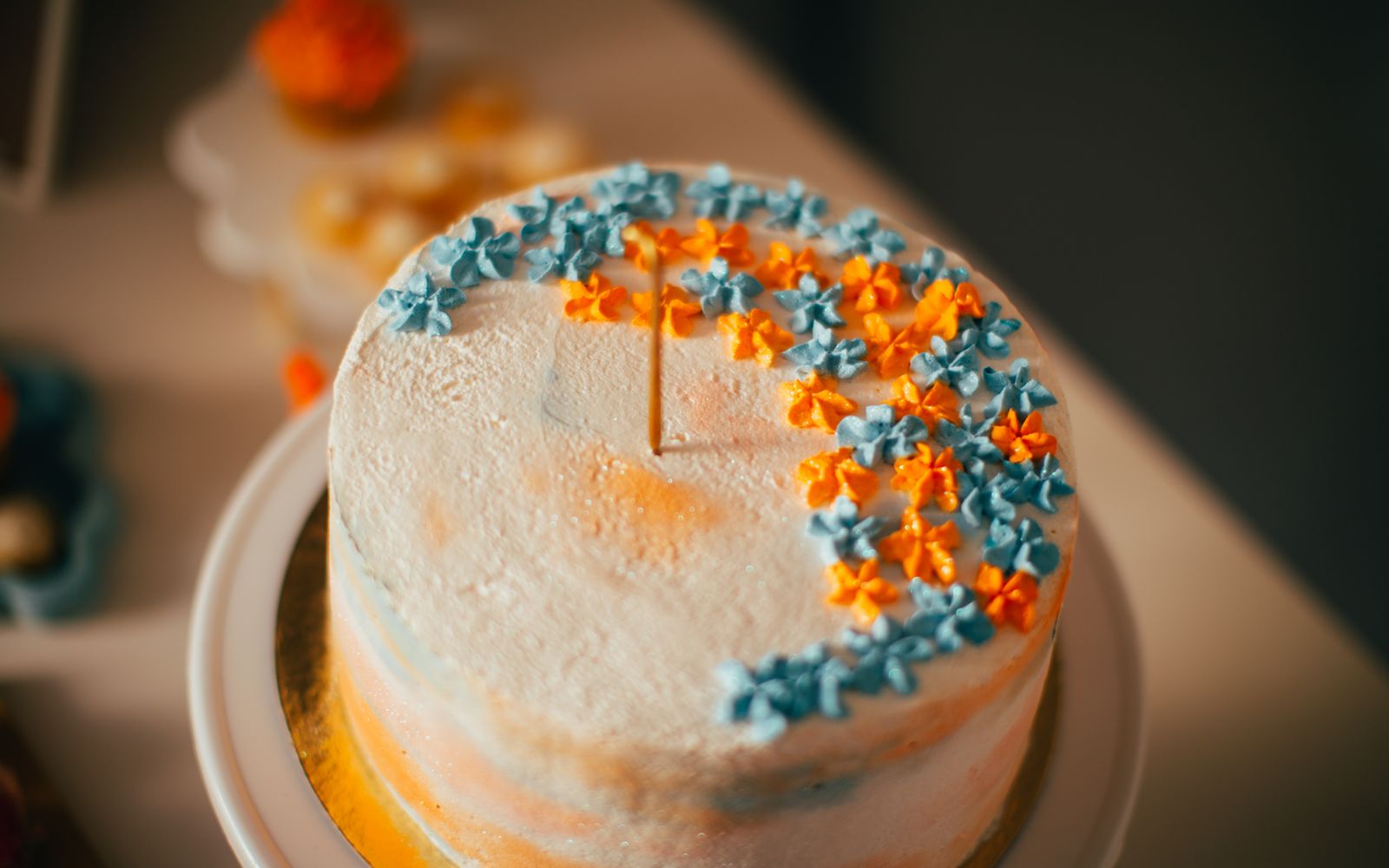 Bolo de festa de dois andares decorado com flores e detalhes em rosa e dourado