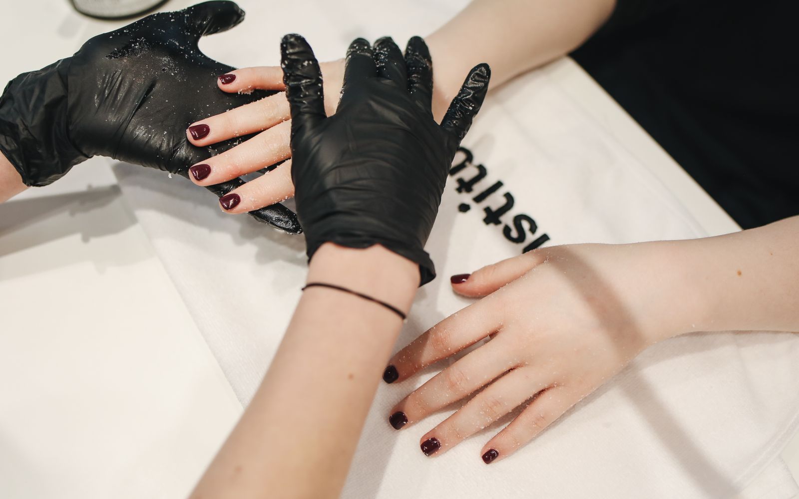 Mãos com unhas delicadas e bem feitas em destaque sobre fundo suave