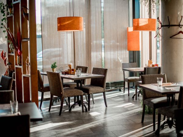 Salão aconchegante da cantina italiana com mesas postas e luz quente