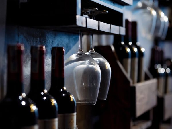 Taça de vinho tinto servida em mesa rústica de madeira