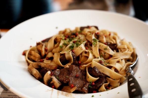 Tagliatelle al ragù com molho de carne e parmesão servido em prato fundo